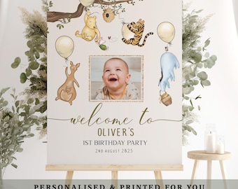 May include: A personalized party sign featuring a photo of a baby, Winnie the Pooh characters, and balloons. The sign reads "welcome to Oliver's 1st Birthday Party 2nd August 2025". The sign is displayed on an easel.