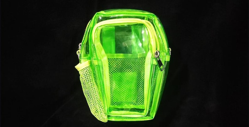 May include: A neon green transparent crossbody bag with a zippered main compartment and a front mesh pocket. The bag has a yellow zipper and a matching yellow mesh pocket. The bag is made of a clear, see-through material.
