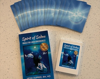 May include: A deck of blue oracle cards with a white and blue design, a book, and a smaller card box. The book and box are titled "Spirit of Sedna" and feature an underwater illustration of a mermaid. The book has a "Best New Book Finalist" sticker.