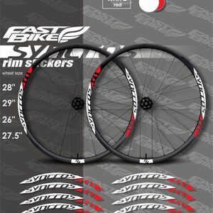 May include: A set of white and red rim stickers for bicycle wheels. The stickers feature the word "Syncros" in a white and red design. The stickers are available in sizes 28", 29", 26", and 27.5".