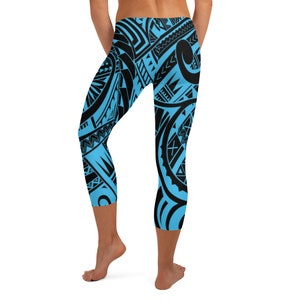 May include: Blue and black capri leggings with a tribal pattern. The leggings feature a light blue background with a repeating black design. The capri leggings are knee-length and form-fitting.