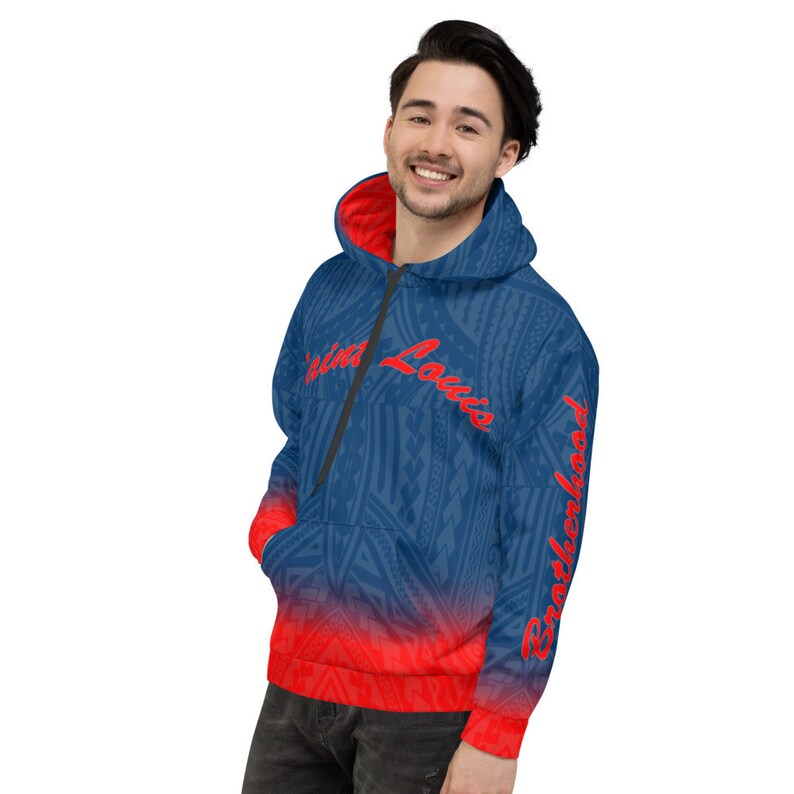 May include: Blue hoodie with a red and blue tribal pattern and a red interior. The hoodie has the words "Saint Louis" and "Brotherhood" in red script. The hoodie has a front pocket and a zipper.
