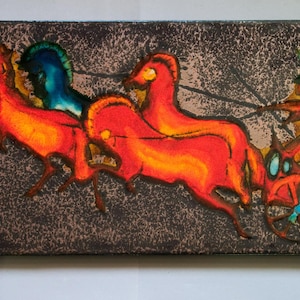 May include: A rectangular wall plaque featuring a vibrant enamel scene of two bright orange horses pulling a chariot with a driver. The background is a textured dark brown with a mottled finish, and the chariot wheels and driver are detailed in blue.