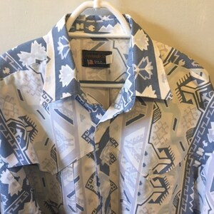 May include: A blue and white patterned button-up shirt with a label that reads "Panhandle Slim" on the front.
