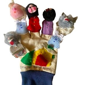 May include: A Little Red Riding Hood finger puppet glove. The glove is beige with a blue cuff and features finger puppets of the characters. The puppets include Little Red Riding Hood, the wolf, and the grandmother.