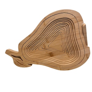 May include: A natural wood fruit bowl shaped like a pear. The bowl is made of multiple layers of wood that are stacked on top of each other. The bowl is a light brown color.