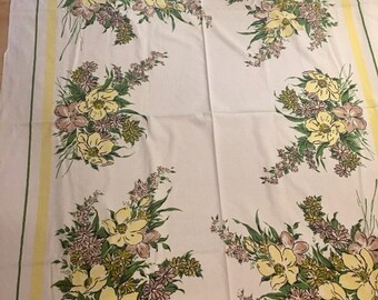 Könnte beinhalten: Weiße Tischdecke mit gelbem Rand und einem Blumendesign aus gelben, grünen und rosa Blüten.