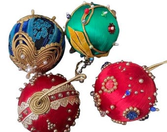 May include: Four vintage Christmas ornaments made of fabric and decorated with beads and sequins. The ornaments are red, green, blue, and gold.