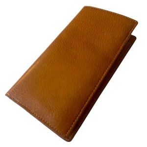 May include: A rectangular, tan leather wallet with a textured surface. The wallet is closed and has a stitched border. The leather has a warm, golden-brown hue. The wallet is designed to hold cards and cash.