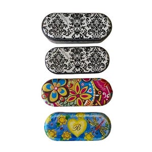 May include: Four oval-shaped eyeglass cases. Two cases feature a black and white damask pattern. The other two cases have colorful floral and nature-themed designs. One case has a yellow heart with the letter "B".