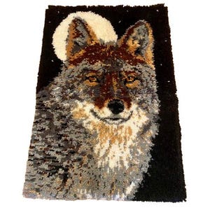 May include: A rectangular rug featuring a detailed image of a wolf's face against a black background with a full moon. The wolf's fur is depicted in shades of gray, brown, and beige. The rug is likely made of woven or tufted material.