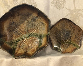 May include: Two ceramic dishes with a brown and green glaze. The dishes are shaped like a five-pointed star and have a textured surface.