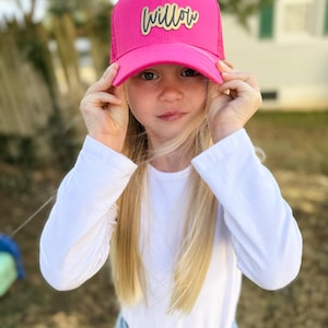 May include: A pink trucker hat with a gold mesh back and a gold "Willow" patch on the front.