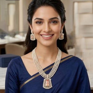 May include: A multi-strand white pearl necklace featuring a rectangular pendant with a central floral design and a diamond-encrusted border, paired with matching rectangular drop earrings. The text NEC - 7A is visible in the upper left corner.