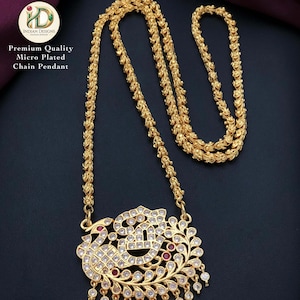 May include: Gold-toned micro-plated chain pendant with a detailed peacock design. The pendant features clear and red gemstones, with a chain that has a textured, rope-like appearance. The image includes text that reads "Premium Quality Micro Plated Chain Pendant."