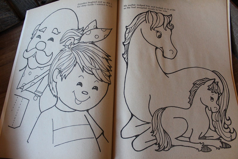 May include: A black and white illustration of a boy with a bow in his hair standing next to a man with a mustache and a polka dot tie. The text "Grandpa laughed and so did I, but deep inside I wanted to cry." is written above the illustration. On the right side of the page, a black and white illustration of a horse and a foal. The text "His mother nudged him and looked on in pride as the foal snuggled closely to her side." is written above the illustration.