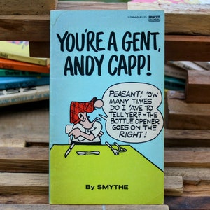 May include: A vintage comic book cover featuring a cartoon character with a red hat and a speech bubble that says "PEASANT! 'OW MANY TIMES DO I 'AVE TO TELLYER?-THE BOTTLE OPENER GOES ON THE RIGHT!" The title of the comic book is "YOU'RE A GENT, ANDY CAPP!" and the author is "By SMYTHE".