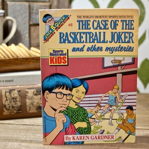 May include: A vintage book titled "The Case of the Basketball Joker and other mysteries" by Karen Gardner. The cover features cartoon illustrations of children playing basketball. The book is part of the Sports Illustrated Kids series.