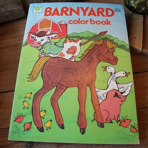 May include: A vintage coloring book with a colorful illustration of a brown horse, a cow, a chicken, and two geese. The book cover features the title "BARNYARD color book" and a red barn.