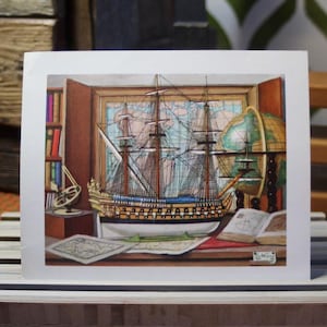 May include: A detailed model of a sailing ship sits on a table with a globe, books, and maps. The ship is made of wood and has a blue hull and white sails. The globe is a classic style with a blue and green map. The books are leather-bound and have a vintage look. The maps are spread out on the table and show the world.
