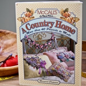 May include: A book titled "A Country Home" by McCall's Createa with a floral design on the cover. The book features more than 40 projects to make.