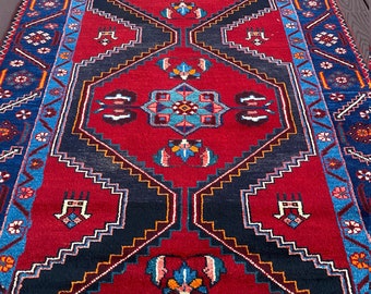 May include: A red, blue, and black patterned rug with intricate geometric designs. The rug has a long, narrow shape and is perfect for a hallway or entryway.