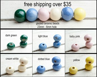 May include: Six ceramic beads in various colors, including dark green, light blue, baby pink, cream white, dotted blue, and yellow. Each bead is 23mm in diameter with a 6mm hole. The beads are arranged in two rows of three, with the top row showing the beads individually and the bottom row showing two beads stacked on top of each other.
