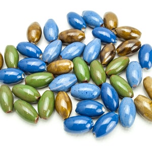 Peut inclure: Un ensemble de perles en céramique de couleur bleue, verte et marron. Les perles sont de forme ovale et ont une finition brillante.