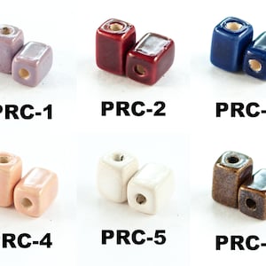 Könnte beinhalten: Sechs Paare quadratischer Keramikperlen in verschiedenen Farben, darunter Lavendel, Rot, Blau, Rosa, Weiß und Braun. Jedes Paar ist mit einer Nummer von 1 bis 6 gekennzeichnet.