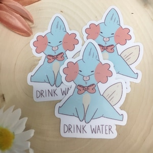 Puede incluir: Tres pegatinas de axolotl de dibujos animados azul y rosa con el texto "Drink Water" en cada una. Los axolotls llevan una pajarita y tienen la lengua fuera.