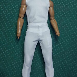 K&ouml;nnte beinhalten: Wei&szlig;es &auml;rmelloses Hemd und wei&szlig;e Hose f&uuml;r eine Puppe oder eine Actionfigur.