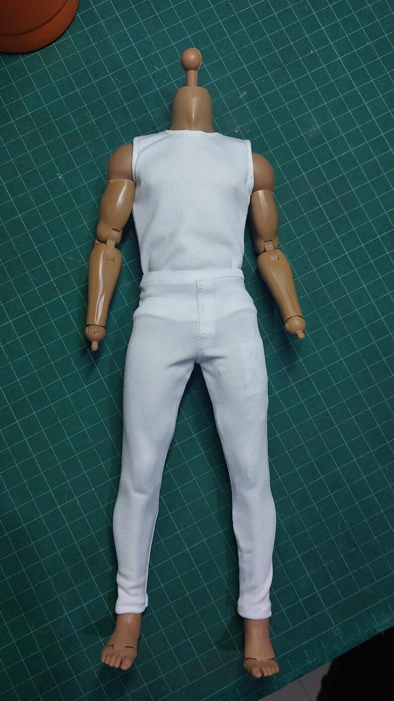 K&ouml;nnte beinhalten: Wei&szlig;es &auml;rmelloses Hemd und wei&szlig;e Hose f&uuml;r eine Puppe oder eine Actionfigur.