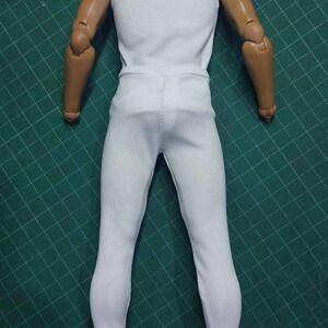 K&ouml;nnte beinhalten: Eine wei&szlig;e &auml;rmellose Bluse und eine wei&szlig;e Hose an einer Puppe.
