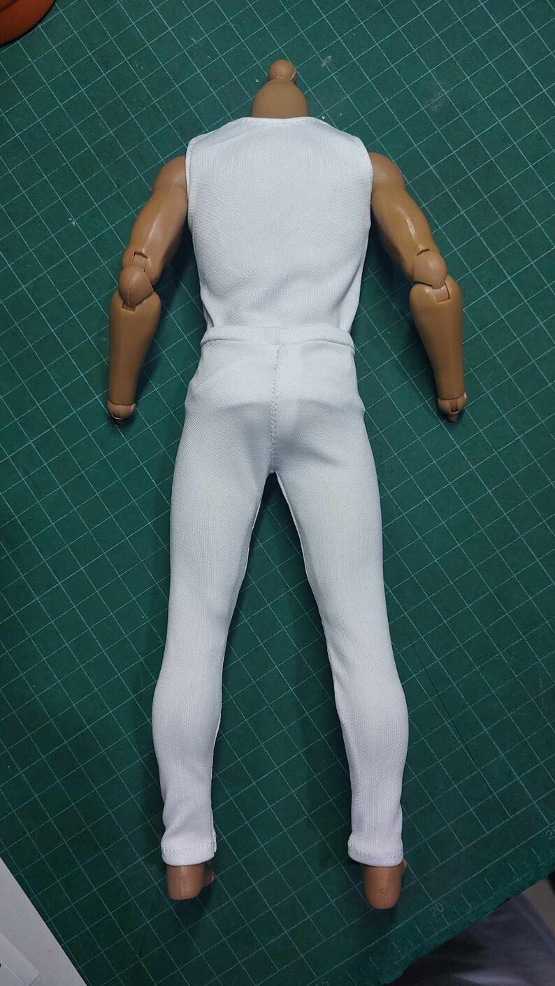 K&ouml;nnte beinhalten: Eine wei&szlig;e &auml;rmellose Bluse und eine wei&szlig;e Hose an einer Puppe.
