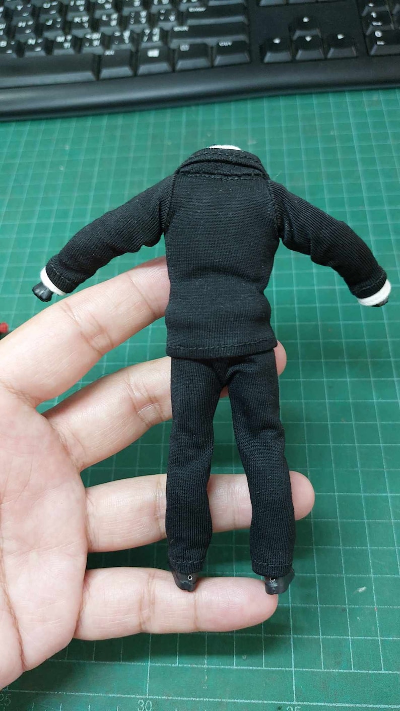 Op de afbeelding: Een zwart pak met een jas en broek. Het pak is gemaakt van een zachte, rekbare stof. De jas heeft een kraag en lange mouwen. De broek heeft een rechte pijp.