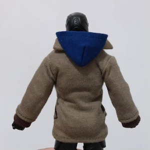 May include: A brown hooded jacket with a blue hood. The jacket has a ribbed texture and long sleeves.
