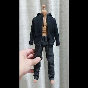Peut inclure: Un sweat à capuche noir et un pantalon de survêtement gris sur un mannequin.