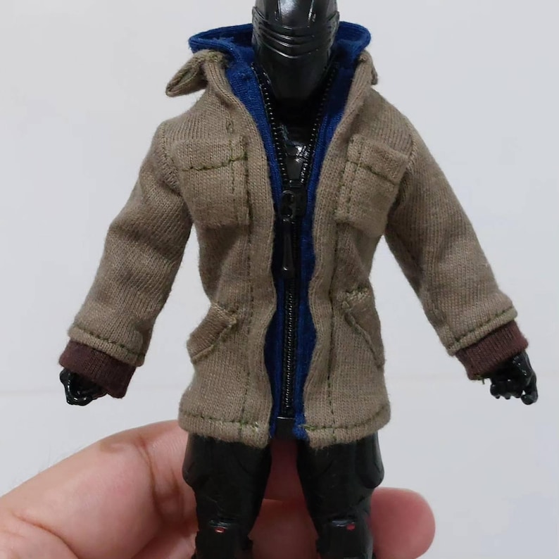 May include: A brown hooded jacket with a blue lining and brown cuffs. The jacket has a zip closure and two pockets on the front.