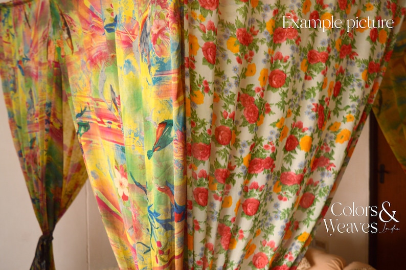 May include: Two sheer curtains with floral patterns. The curtain on the left has a colorful abstract design with birds and flowers. The curtain on the right has a white background with red, yellow, and green flowers. The text "Colors & Weaves India" is visible in the bottom right corner.