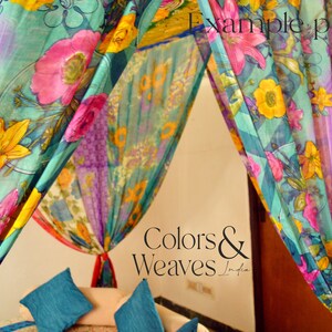 May include: A canopy bed with colorful floral patterned fabric drapes. The fabric is sheer and has a light, airy feel. The bed is made up with teal blue pillows. The text "Colors & Weaves India" is visible in the image.