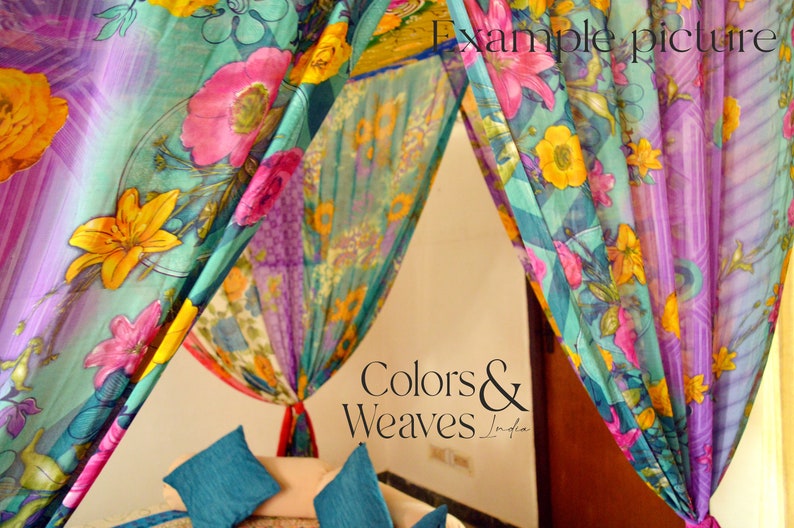 May include: A canopy bed with colorful floral patterned fabric drapes. The fabric is sheer and has a light, airy feel. The bed is made up with teal blue pillows. The text "Colors & Weaves India" is visible in the image.