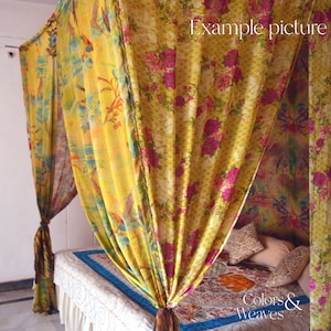 May include: A yellow and pink floral patterned canopy bed with a white bedspread and pillows. The canopy is made of sheer fabric and has a floral design. The bed is decorated with a colorful throw pillow and a small rug. The text "Colors & Weaves" is visible in the bottom right corner of the image.