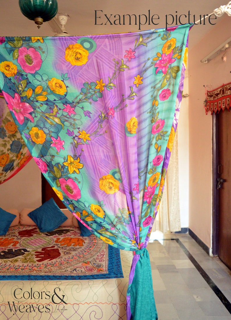 May include: A colorful floral patterned canopy bed curtain with a teal blue trim. The curtain is tied back with a knot and hangs over a bed with a patterned bedspread. The bedspread features a repeating pattern of elephants.