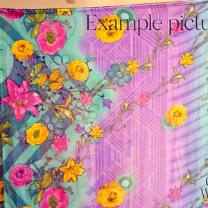 May include: A colorful fabric with a floral pattern in shades of pink, yellow, and green. The fabric has a gradient background that transitions from purple to blue. The text "Example picture" is printed in the upper right corner of the fabric. The text "Colors & Weaves India" is printed in the lower right corner of the fabric.