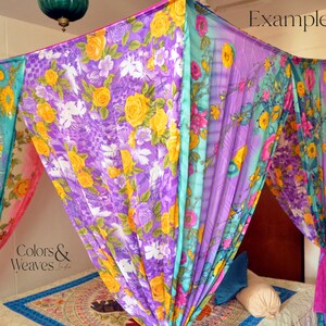 May include: A colorful floral canopy made from fabric, draped over a bed. The canopy is made of four panels of fabric, each with a different floral pattern. The fabric is sheer and lightweight, and the canopy is tied to the ceiling with ropes. The bed is made with a patterned bedspread and pillows. The text "Colors & Weaves" is visible in the image.