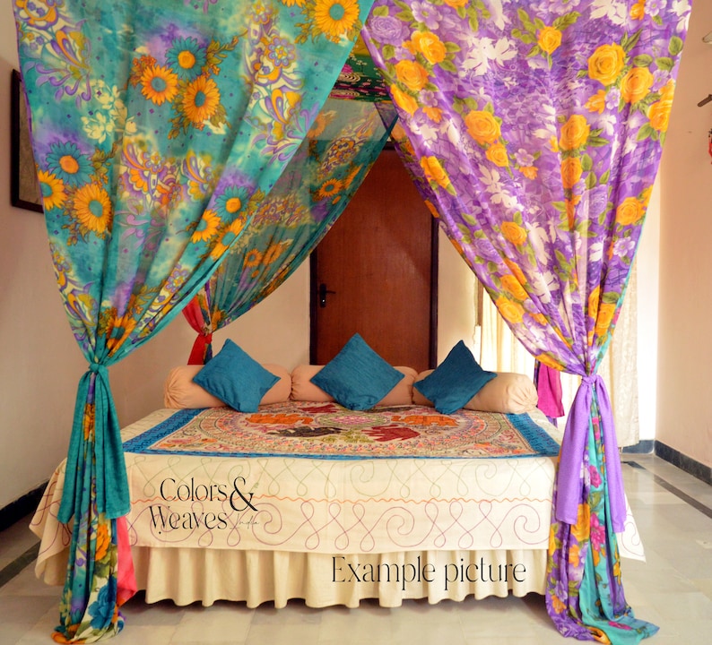 May include: A bed with a canopy made of colorful floral patterned fabric. The canopy is draped over the bed and tied at the corners. The bed has a white bedspread and a patterned throw pillow. The text "Colors & Weaves" is visible on the bedspread. The text "Example picture" is visible at the bottom of the image.