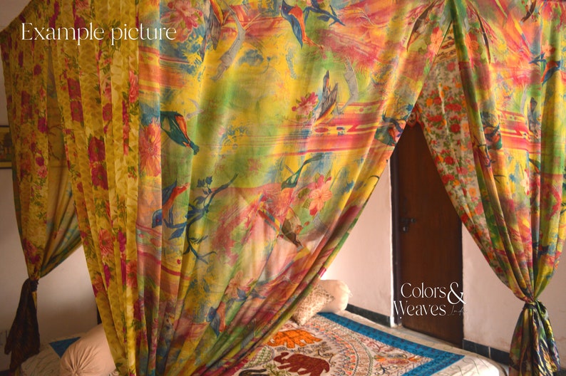 May include: A colorful canopy bed with a floral and bird print. The canopy is made of sheer fabric and hangs from the ceiling. The bed is made up with a white sheet and a patterned rug.