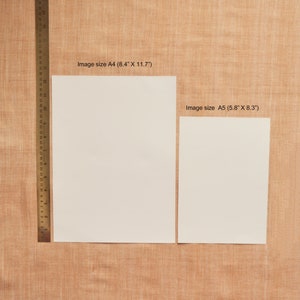 Puede incluir: Dos hojas de papel blancas sobre un fondo de tela marr&oacute;n. La hoja de papel m&aacute;s grande est&aacute; etiquetada "Image size A4 (8.4" X 11.7")" y la hoja de papel m&aacute;s peque&ntilde;a est&aacute; etiquetada "Image size A5 (5.8" X 8.3")".