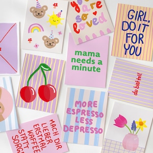 Könnte beinhalten: Eine Sammlung farbenfroher Grußkarten mit verschiedenen Designs und Texten. Einige Karten zeigen Illustrationen von Kirschen, Bären und Blumen. Andere Karten haben Sätze wie "Girl, do it for you" und "More espresso less depresso."