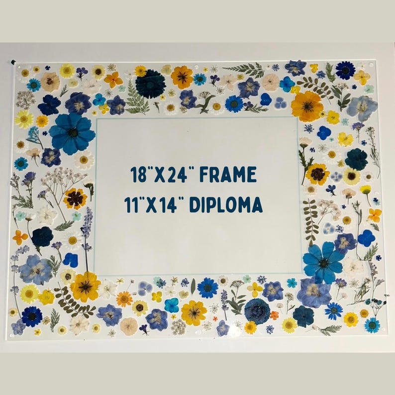 Pode incluir: Uma moldura de acr&iacute;lico transparente, 45.7 cm x 61 cm, decorada com flores secas em tons de azul, amarelo e branco. A moldura &eacute; projetada para um diploma de 27.9 cm x 35.6 cm. As flores s&atilde;o dispostas ao redor das bordas da moldura.